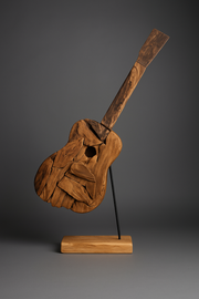 Wooden sculpture of a guitar on a stand against a gray background
